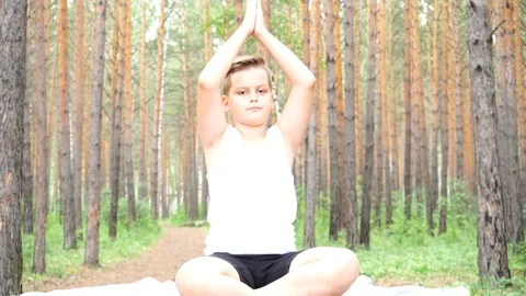 Boy doing yoga in the woods Stock Footage 122120707