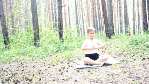 Boy doing yoga in the woods Stock Footage 122120838