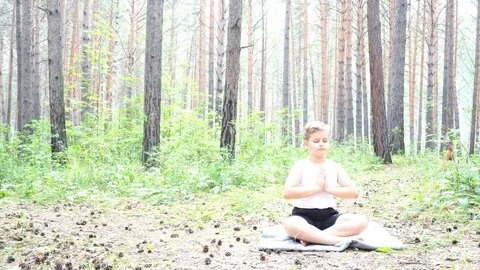 Boy doing yoga in the woods Stock Footage 122120871