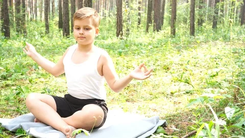 Boy doing yoga in the woods Stock Footage 122120887