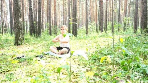 Boy doing yoga in the woods Stock Footage 122120936