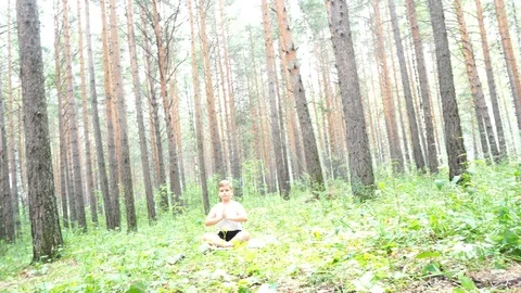 Boy doing yoga in the woods Stock Footage 122121014