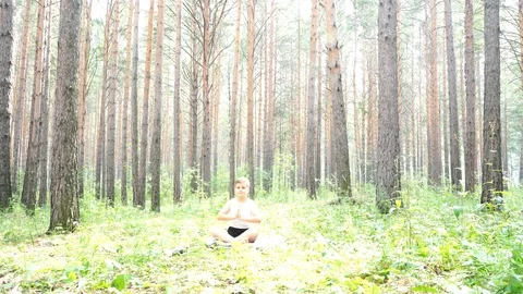 Boy doing yoga in the woods Stock-Footage 122121047