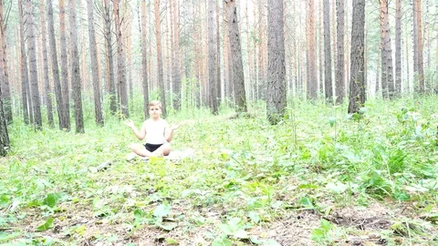 Boy doing yoga in the woods Stock Footage 122121055