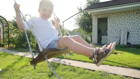 A boy with Down syndrome having fun on a swing with his father. Stock Footage 165042698