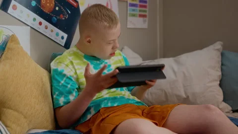 Boy with Down Syndrome Using Digital Tablet for Education Stock Footage 337561189