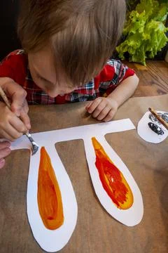 Boy drawing the ears of a handmade Easter bunny made of cardboard. Preparatio Stock Photos