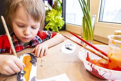 Boy drawing the ears of a handmade Easter bunny made of cardboard. Preparatio Stock Photos