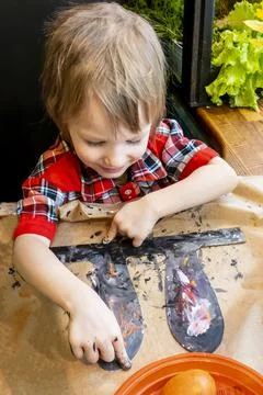Boy drawing the ears of a handmade Easter bunny made of cardboard. Preparatio Stock Photos