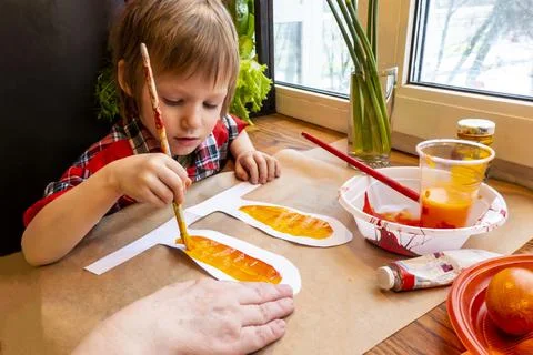 Boy drawing the ears of a handmade Easter bunny made of cardboard. Preparatio Stock Photos