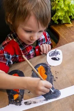 Boy drawing the ears of a handmade Easter bunny made of cardboard. Preparatio Stock Photos