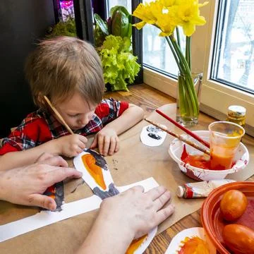 Boy drawing the ears of a handmade Easter bunny made of cardboard. Preparatio Stock Photos