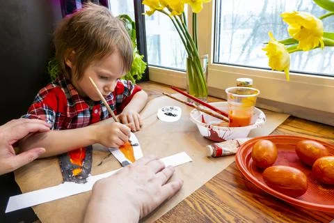 Boy drawing the ears of a handmade Easter bunny made of cardboard. Preparatio Stock Photos