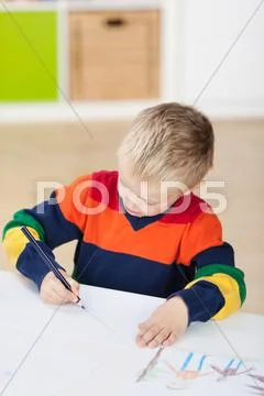 Boy drawing on paper at table Stock Photos