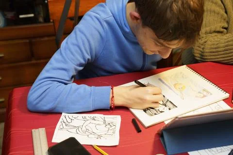 A boy is drawing on a red table Stock Photos