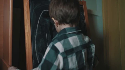Boy draws chalk on the board Stock Footage 129099256