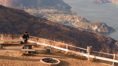 Boy draws the computer to work at a parking area with a panoramic view at sunset Stock Footage 59559981