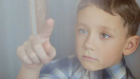 The boy draws a finger on the window Stock Footage 96240991