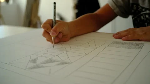 The boy draws geometric shapes with a simple pencil and does shading Stock-Footage 140168313