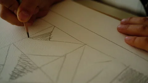 The boy draws geometric shapes with a simple pencil and does shading Stock-Footage 140168337