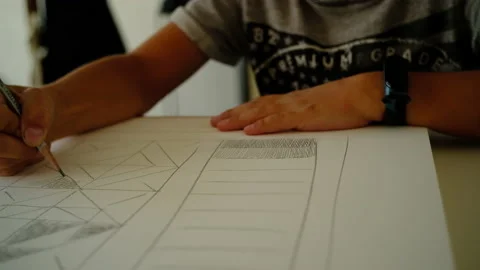 The boy draws geometric shapes with a simple pencil and does shading Video stock 140168361