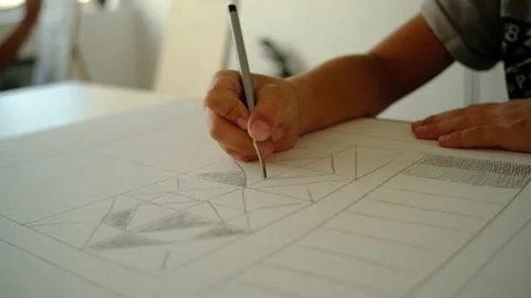 The boy draws geometric shapes with a simple pencil and does shading Stock-Footage 140168363