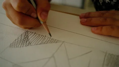 The boy draws geometric shapes with a simple pencil and does shading Stock-Footage 140168401
