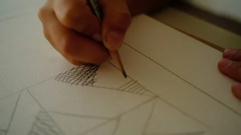 The boy draws geometric shapes with a simple pencil and does shading Stock-Footage 140168410