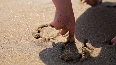 Boy draws his finger on the sand near the sea. Sea vacation for family with kids Stock Footage 113820043