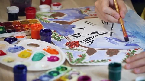 The boy draws a New Years drawing on paper with multi-colored paints Video stock 153867495