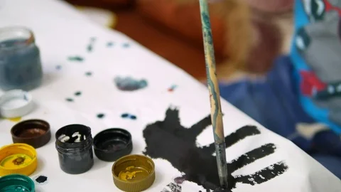 The boy draws paints in the house at the table Stock Footage 76026455