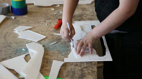 The boy draws the path and carves model airplane Stock Footage 59112687