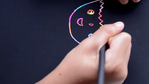 A boy draws on a scratch note colorful Stock Footage 81935035