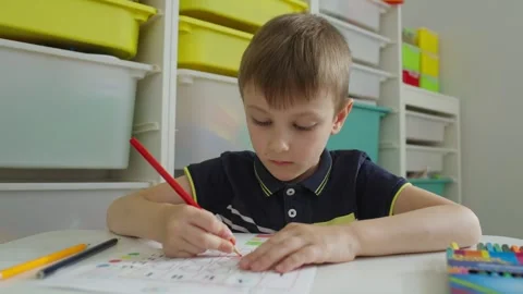 A boy draws on a sheet while doing logic tasks at school. Stock Footage 244524378
