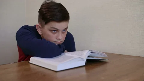 Boy dreams while reading a book Stock Footage 87401562