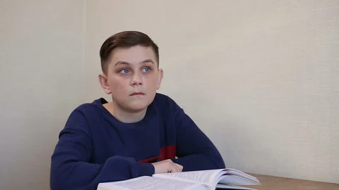 Boy dreams while reading a book Stock Footage 87401688