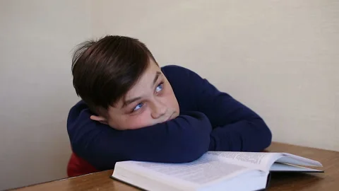 Boy dreams while reading a book Stock Footage 87401816