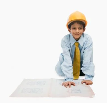 Boy dressed as an architect and working on a blueprint Stock Photos