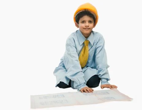 Boy dressed as an architect and working on a blueprint 写真素材