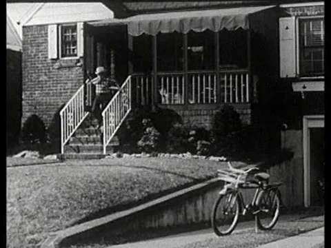 A boy dressed as a cowboy hops on his bicycle and races to the market to buy Stock Footage 74775851