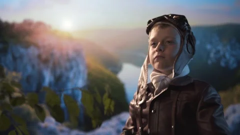 Boy dressed as old pilot looking through binoculars against valley background. Stock Footage 310264429