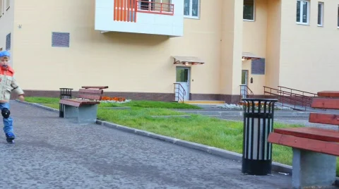 Boy dressed protective equipment rollerblading in city, to camera Stock Footage 589525