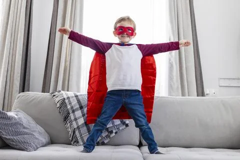 Boy dressed as superhero on couch Stock Photos