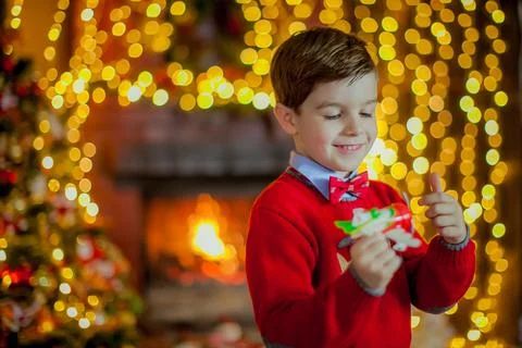 A boy dressed in a sweater against the backdrop of beautiful festive Christmas Stock Photos