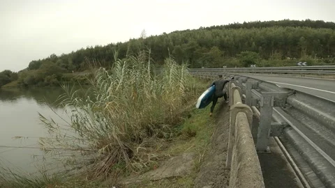 Boy dressed in wetsuit trying to get into the swamp Stock Footage 140928715