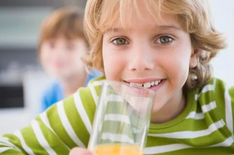Boy drinking a glass of juice Stock Photos