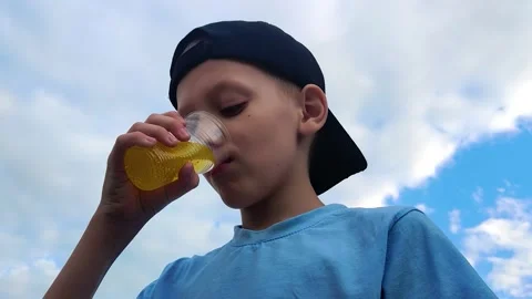 Boy drinking lemonade from a plastic cup Stock Footage 199984260
