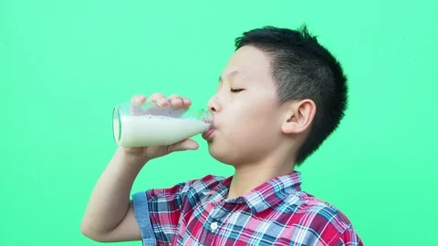 Boy drinking milk in front of green screen Stock Footage 89263740