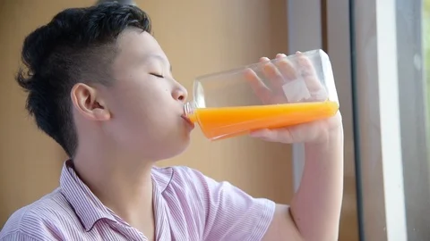 Boy drinking orange juice from bottle,slow motion. Stock Footage 108645790