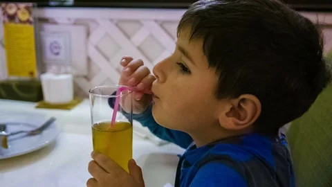 Boy drinks juice through a straw Video stock 75613411